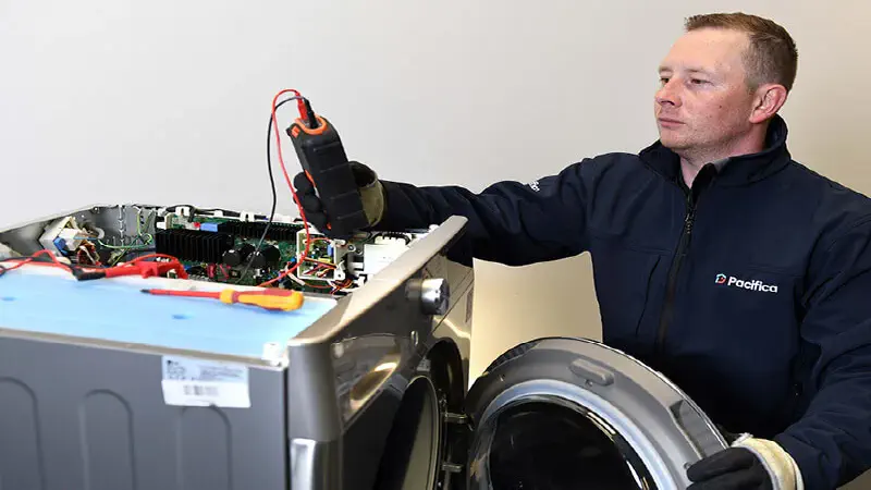 Washing machine paused mid-cycle with indicator light flashing in a Winnipeg home